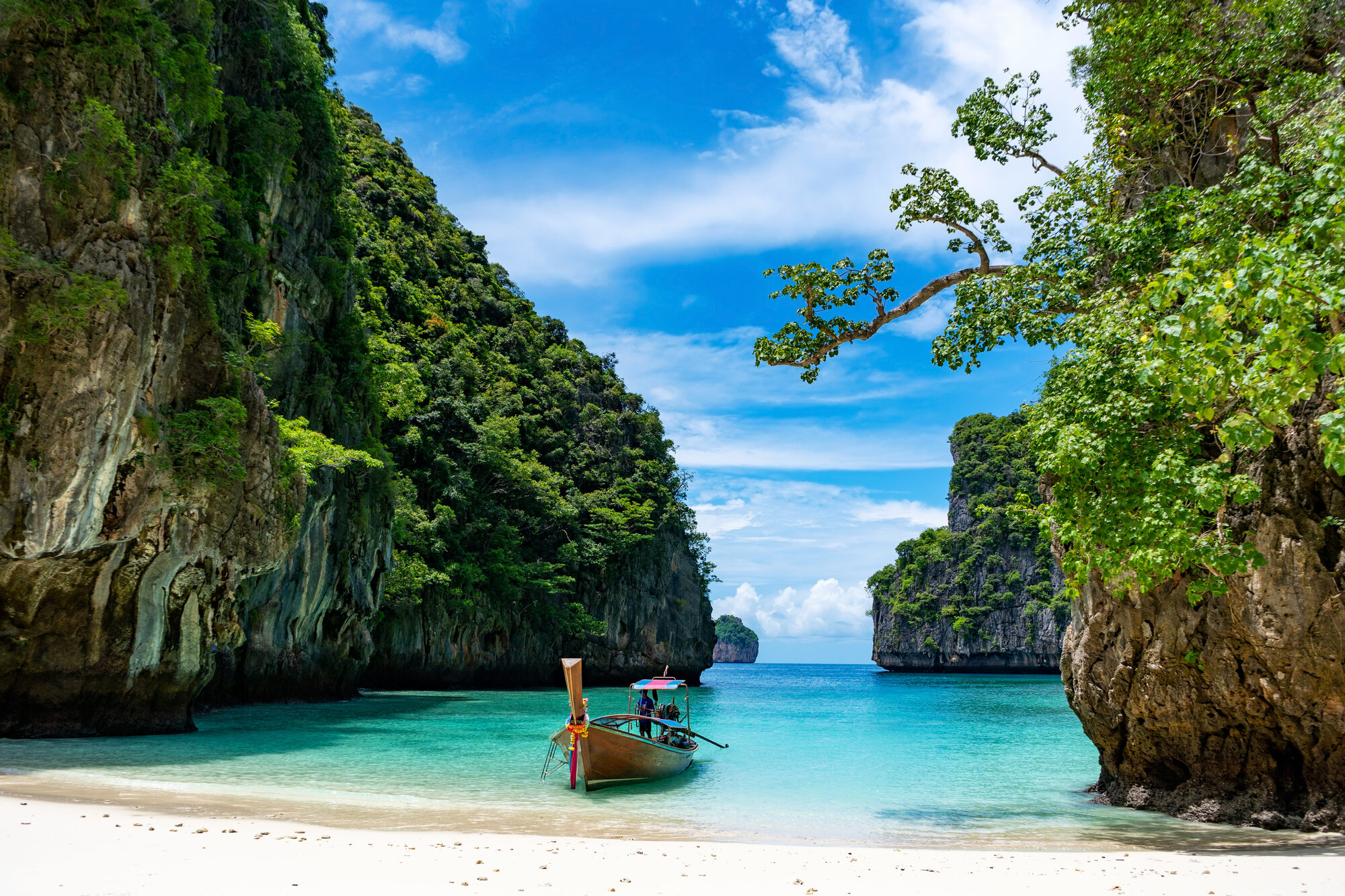 Laguna na wyspach Phi Phi z tradycyjną łodzią longtail i wapiennymi klifami